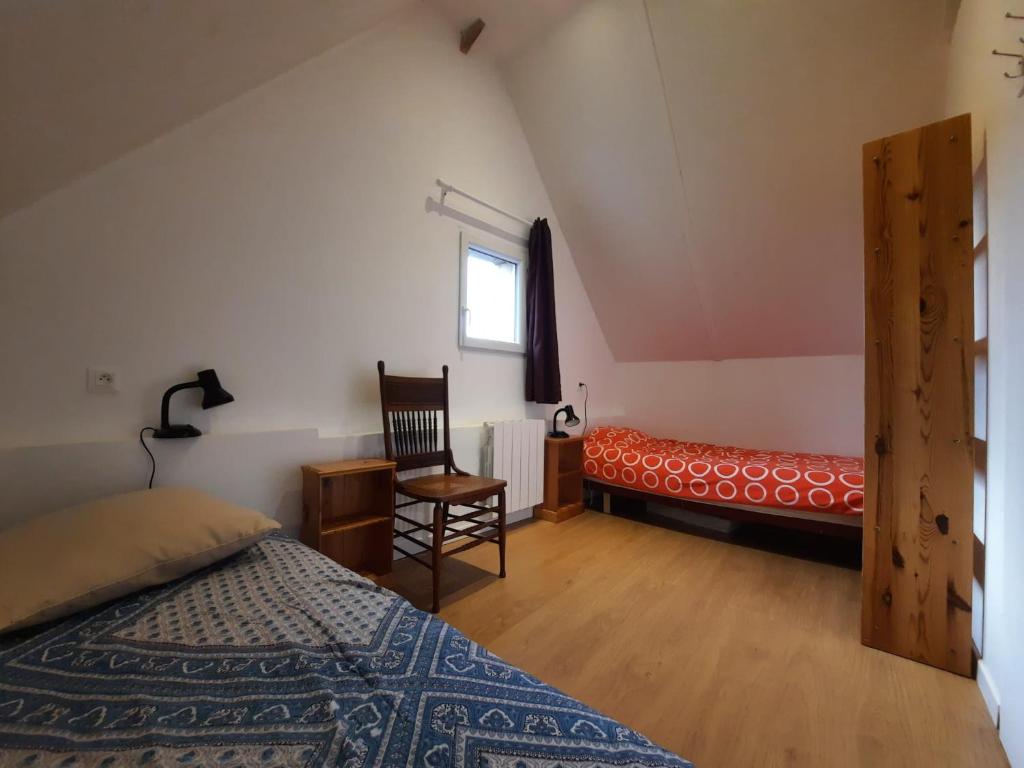 a bedroom with a bed and a chair and a window at Chambre d'hote Frettecuisse in Frettecuisse