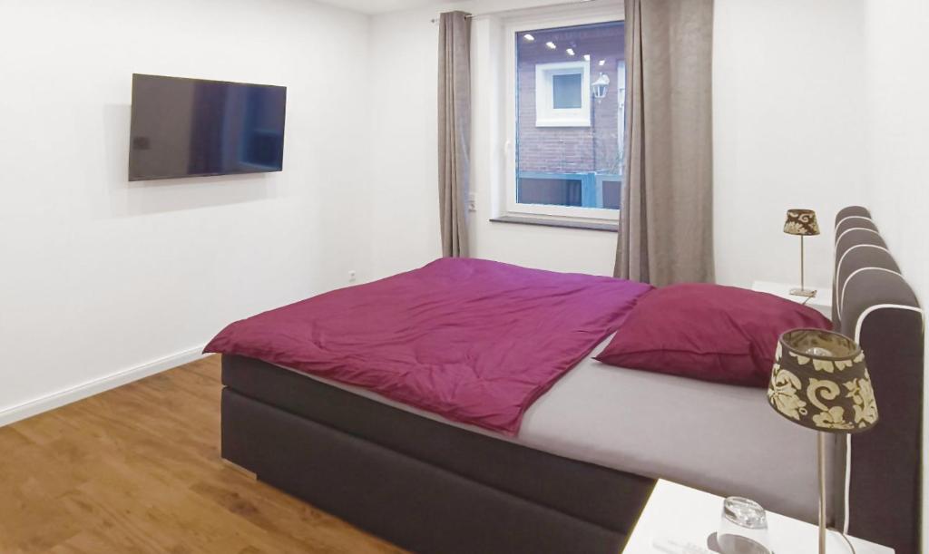 - une chambre avec un lit doté de draps violets et une fenêtre dans l'établissement Moderne Ferienwohnung direkt am Kanal / Neubau, à Emden