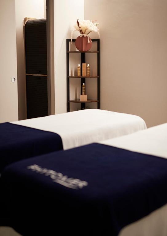 Een bed of bedden in een kamer bij H&ocirc;tel De Brunville &amp; Spa