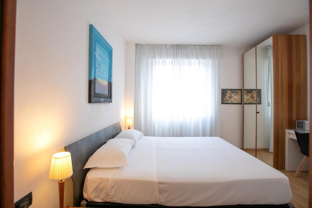 Schlafzimmer mit einem großen weißen Bett und einem Fenster in der Unterkunft Mirea's Rooms in Ascoli Piceno