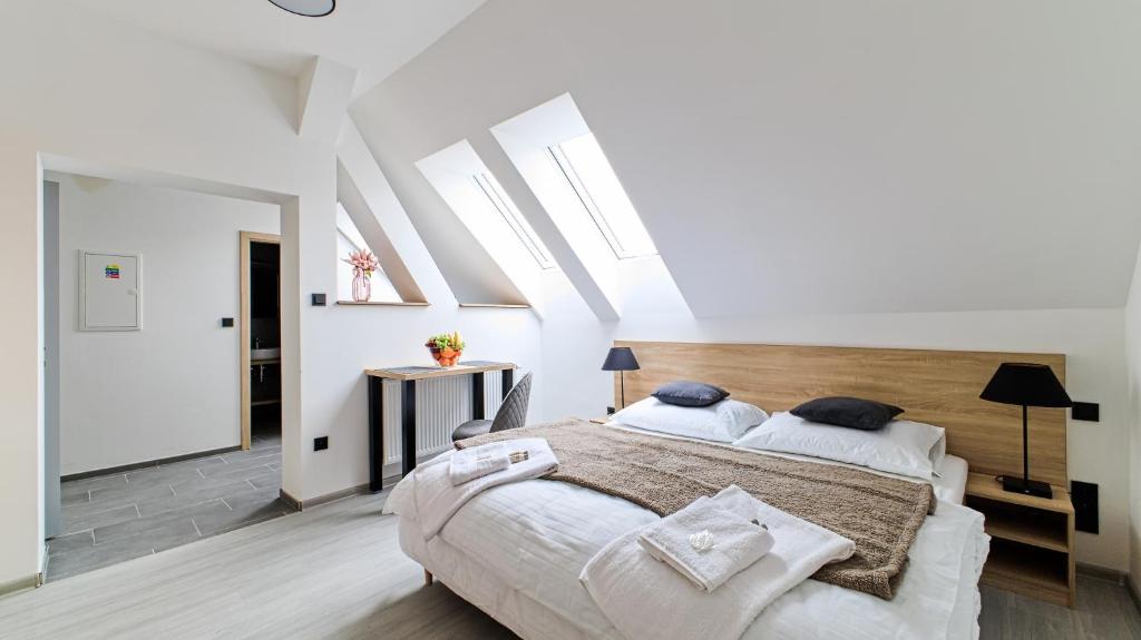 a bedroom with a large bed and skylights at SALAŠKA penzion in Staré Město