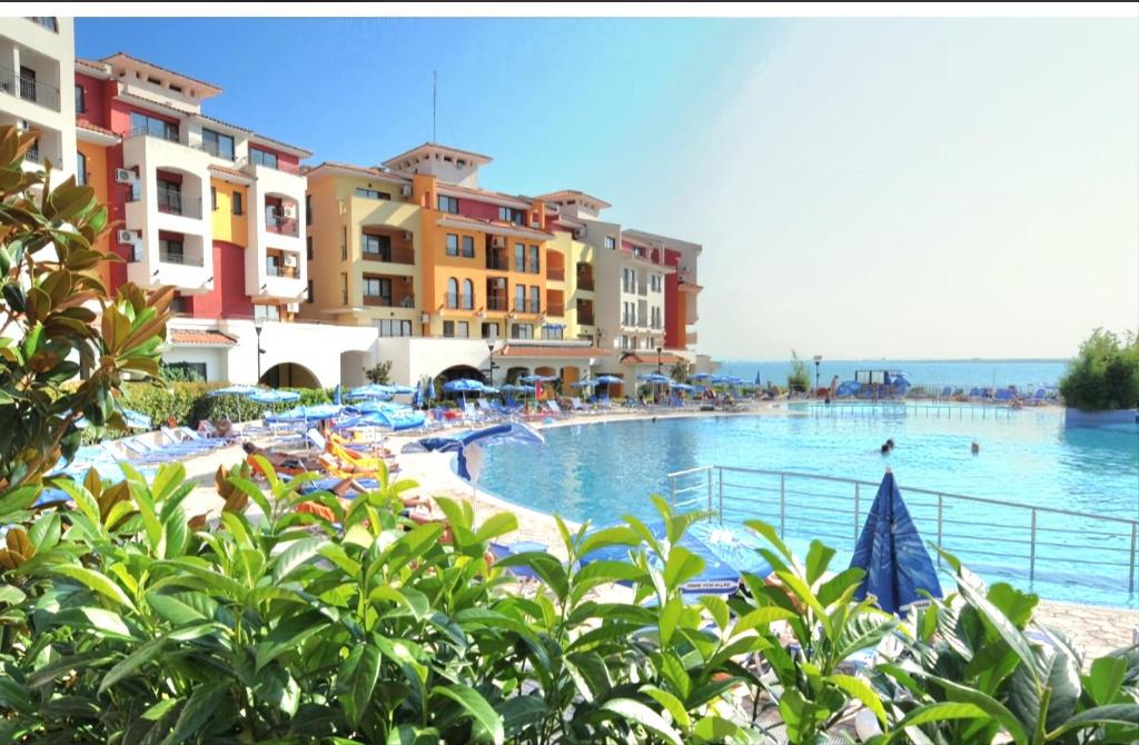 a swimming pool in a resort with people in the water at Marina Cape surprise studio in Aheloy