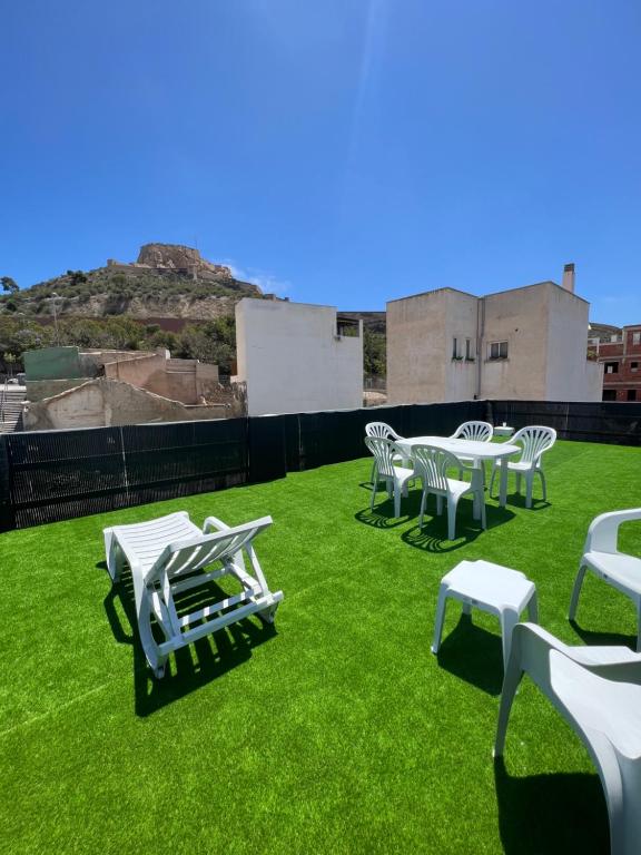 a group of white chairs and tables on a field of grass at CASA DEL CASTILLO in Alicante
