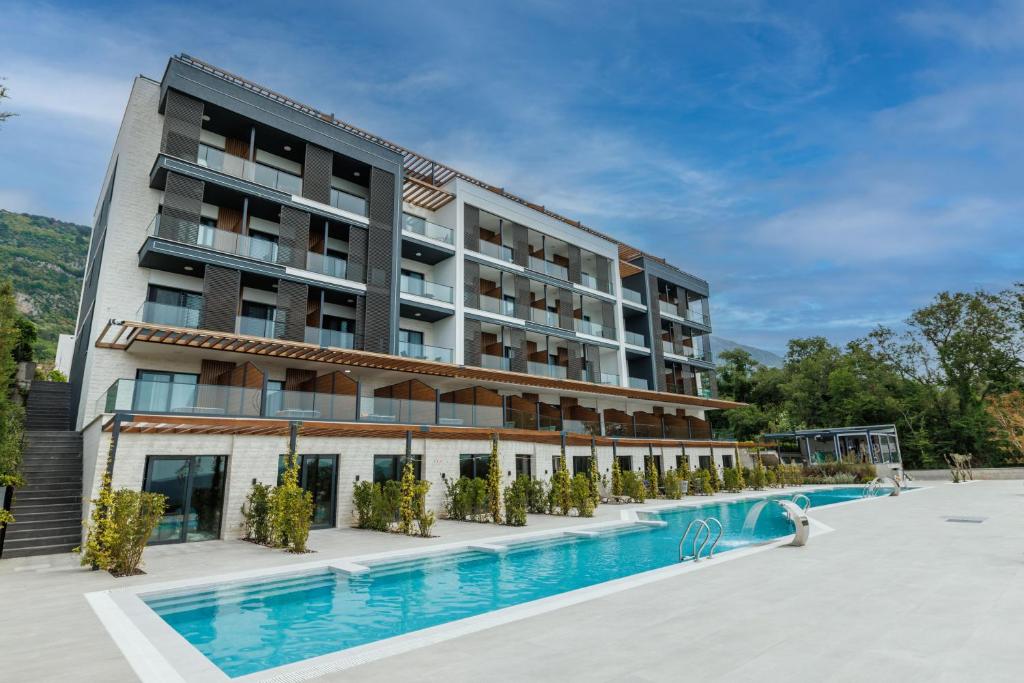 a hotel with a swimming pool in front of a building at Montenegro Lodge in Tivat