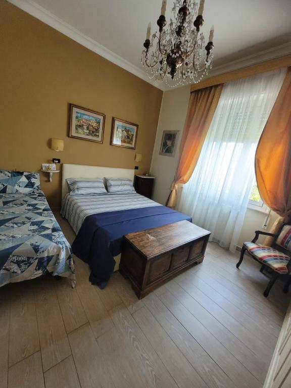 1 dormitorio con cama y lámpara de araña en b&b bellavista en Savona