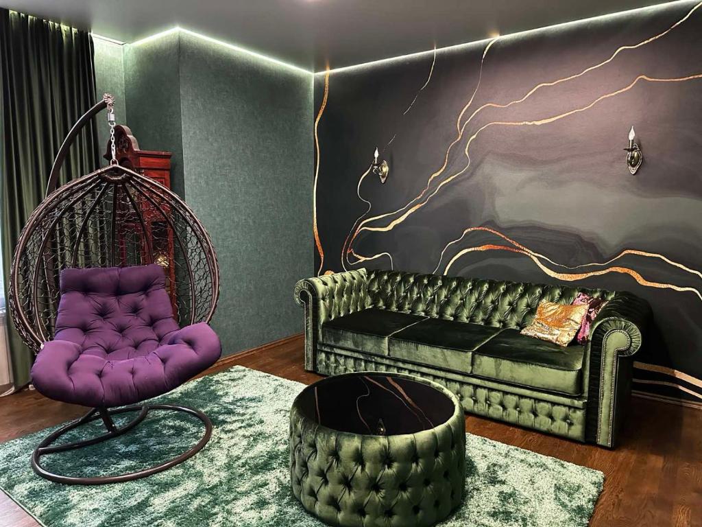 a living room with a couch and a chair at VIP квартира подобово in Luts'k