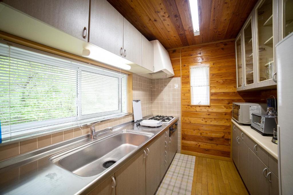 Kuchyň nebo kuchyňský kout v ubytování 鳥の街77号北軽井沢#木の香りに包まれる癒しの木House#吹き抜けのある貸切別荘#BBQ#ダーツ#カラOK#大画面プロジェクター#駐車可