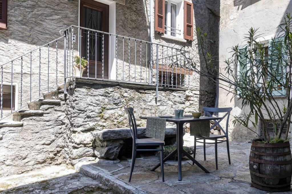stół i krzesła przed budynkiem w obiekcie Rustico Porta w mieście Brissago