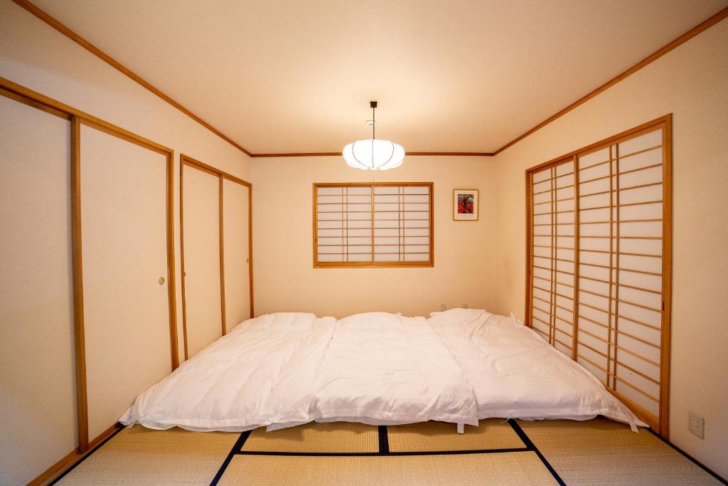 Postel nebo postele na pokoji v ubytování 鳥の街77号北軽井沢#木の香りに包まれる癒しの木House#吹き抜けのある貸切別荘#BBQ#ダーツ#カラOK#大画面プロジェクター#駐車可
