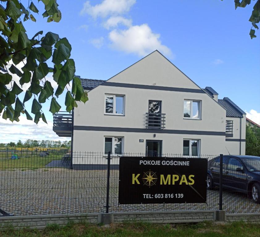 克里尼查謨爾斯卡的住宿－Kompas，前面有标志的白色房子