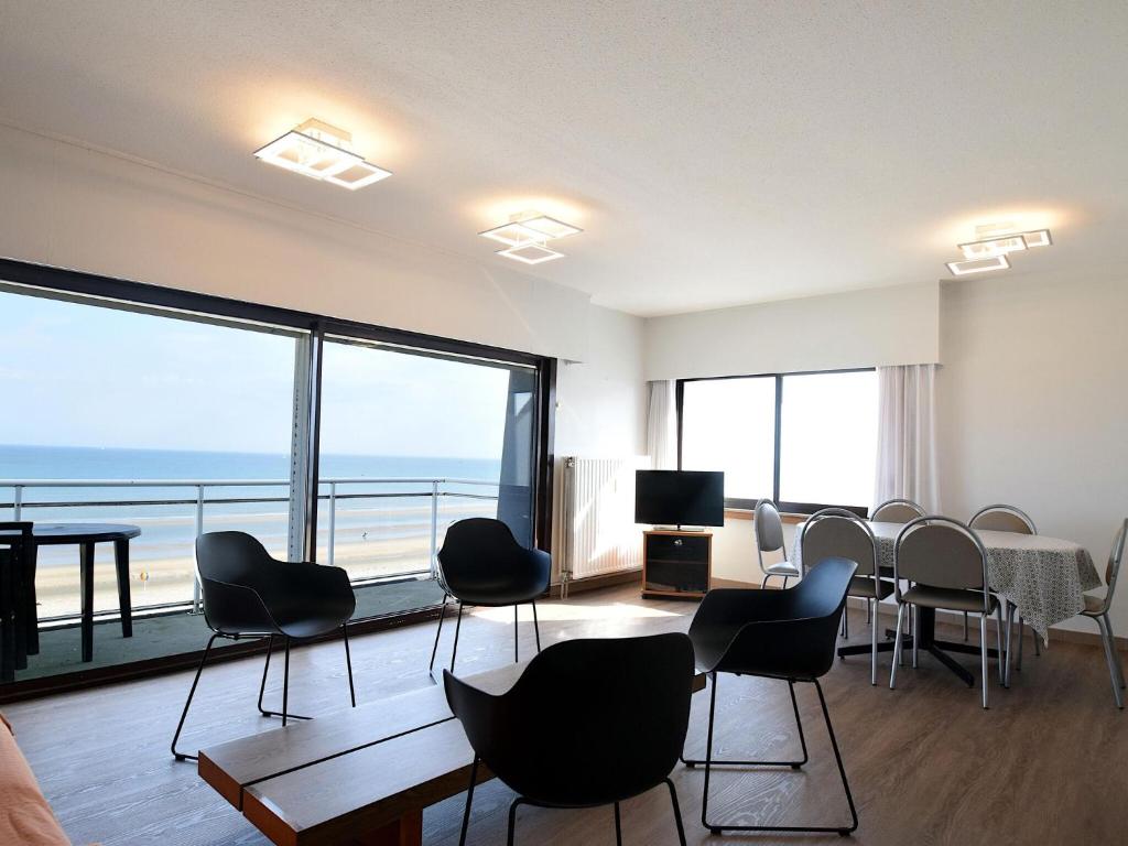 a room with chairs and a table with a view of the ocean at Golf 0401 seafront apartment with balcony in De Haan