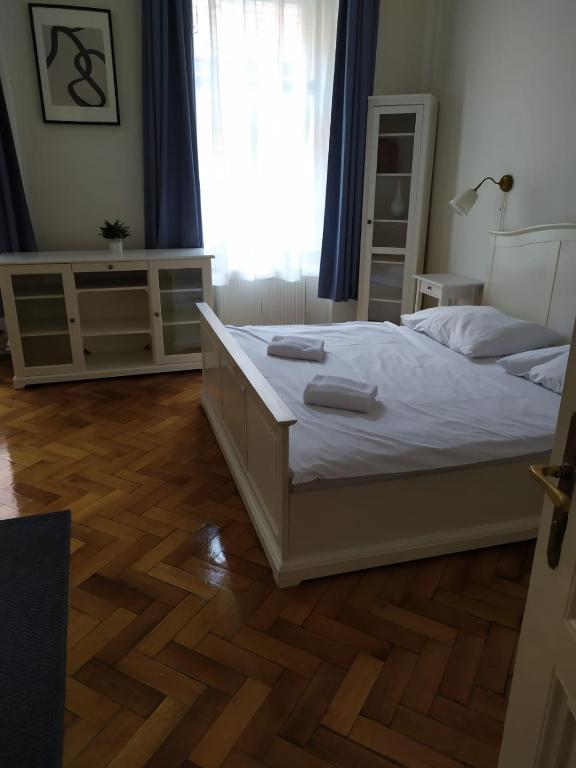 a bedroom with a white bed and a wooden floor at Týnská ulicka 2 - Cathedral View Apartment in Prague