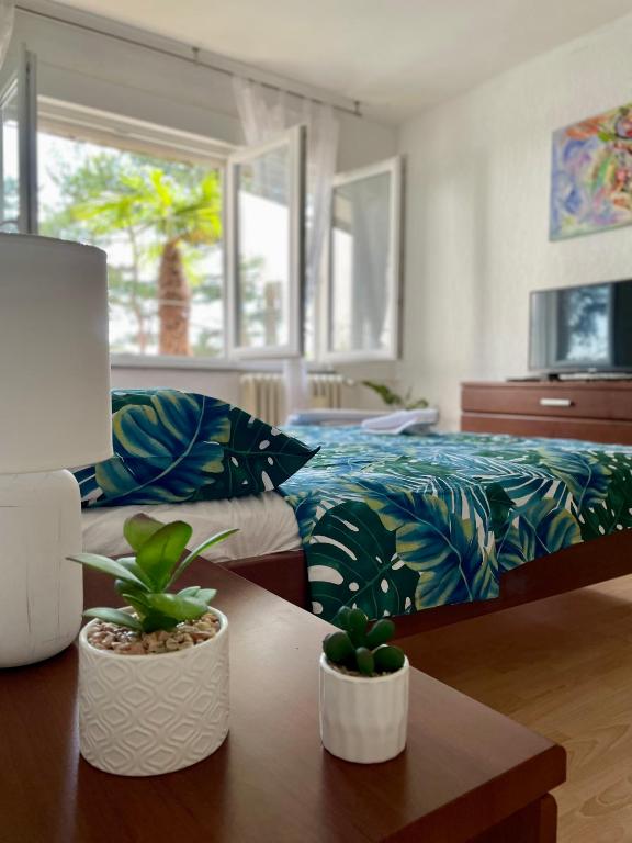 a bedroom with a bed and two potted plants on a table at P&K in Rijeka