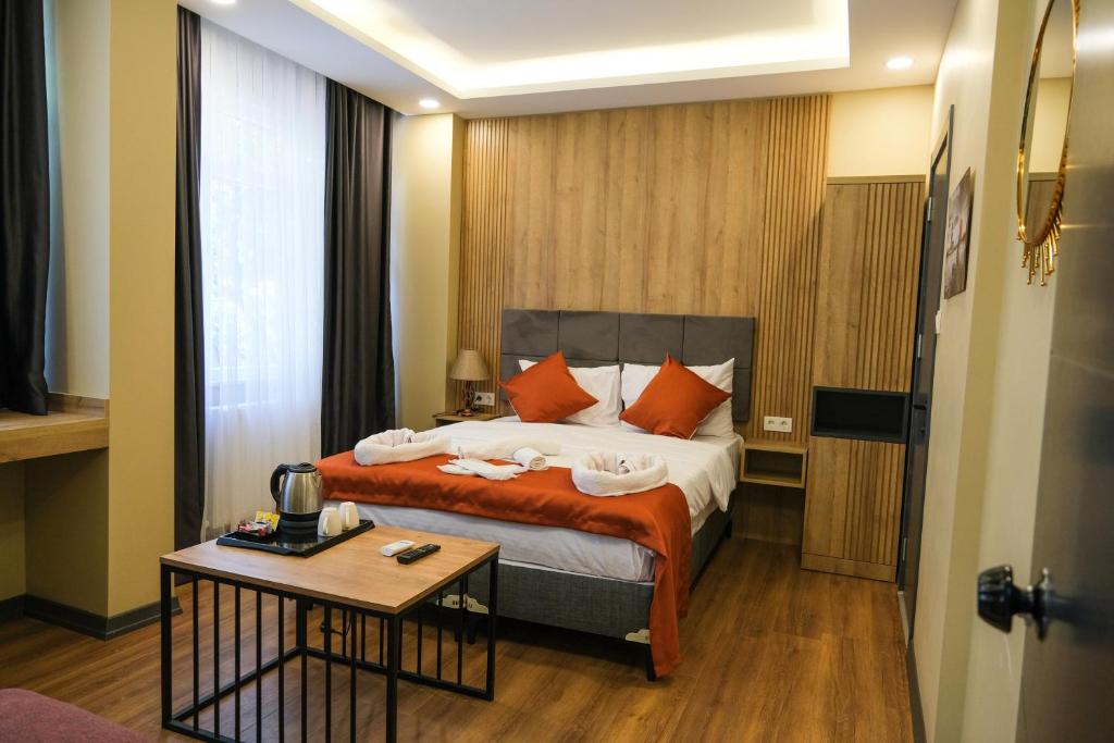 1 dormitorio con cama con almohadas de color naranja y mesa en hotel La Vitrine, en Estambul