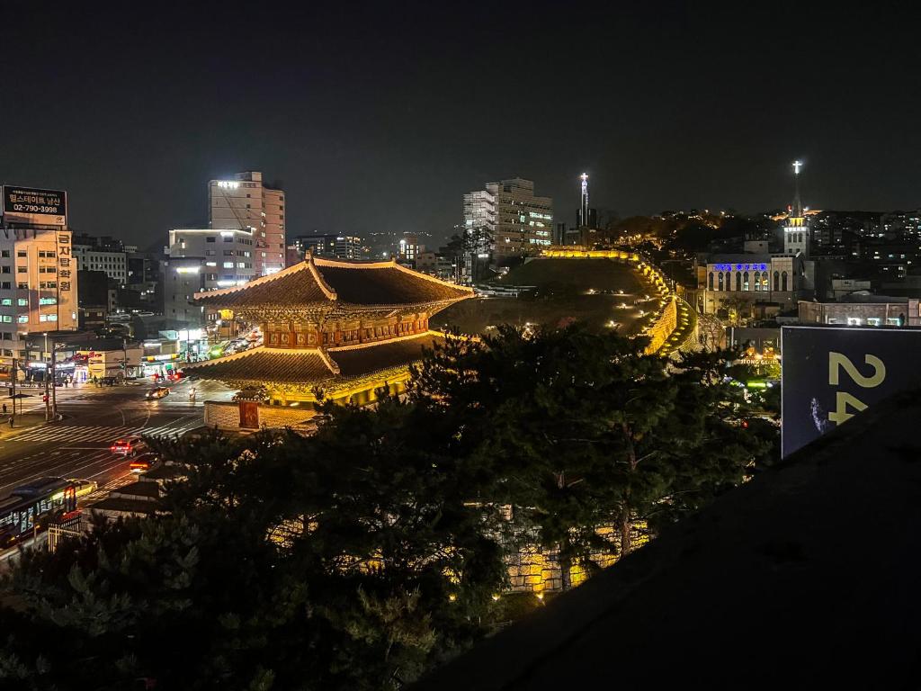 widok na miasto w nocy z budynkiem w obiekcie 24 Guesthouse Dongdaemun Market w Seulu