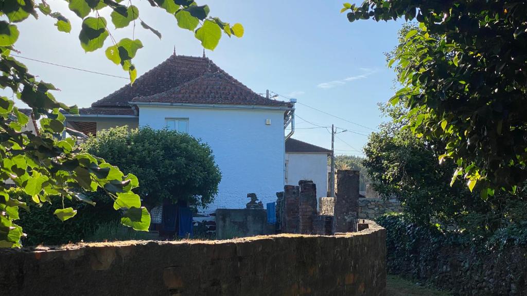 una casa blanca con una valla delante en Vila Feliz 