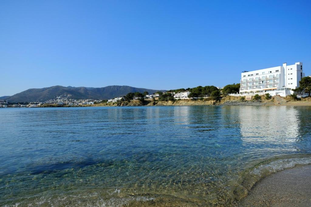 Vue d'une étendue d'eau avec des bâtiments en arrière-plan dans l'établissement Hotel Grifeu, à Llançà