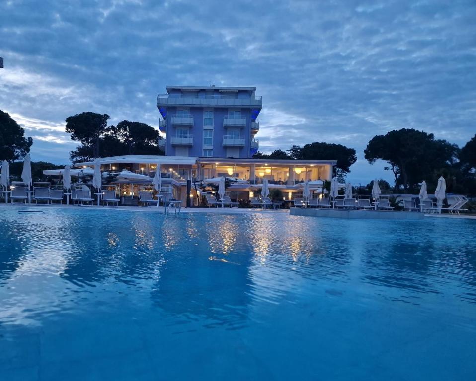 a hotel with a swimming pool in front of a building at Fantinello Hotel in Caorle