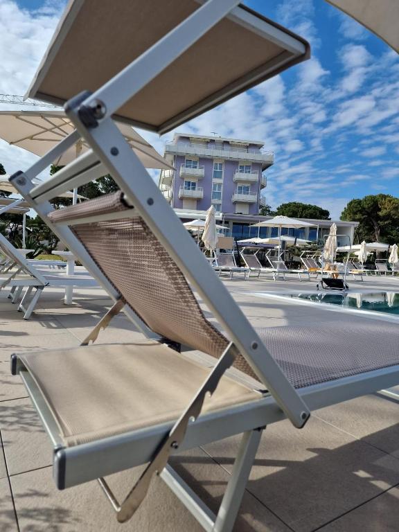 a chair sitting next to a swimming pool at Fantinello Hotel in Caorle