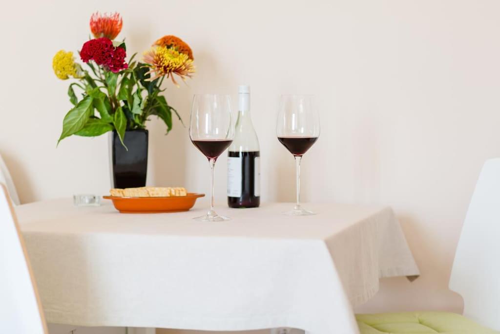 dos copas de vino y un jarrón de flores en una mesa en Dream Apartment Solitudo, en Dubrovnik