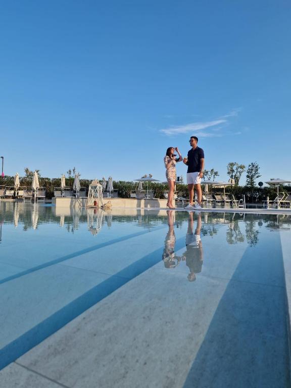 a man and a boy standing in the water at Fantinello Hotel in Caorle