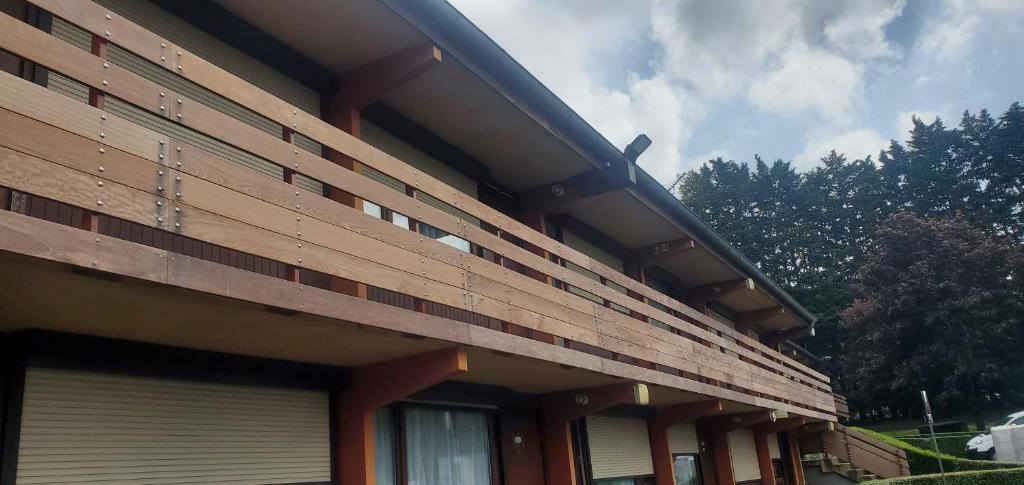 a building with wooden panels on the side of it at KYRIAD HONFLEUR - La Riviere Saint Sauveur in Honfleur