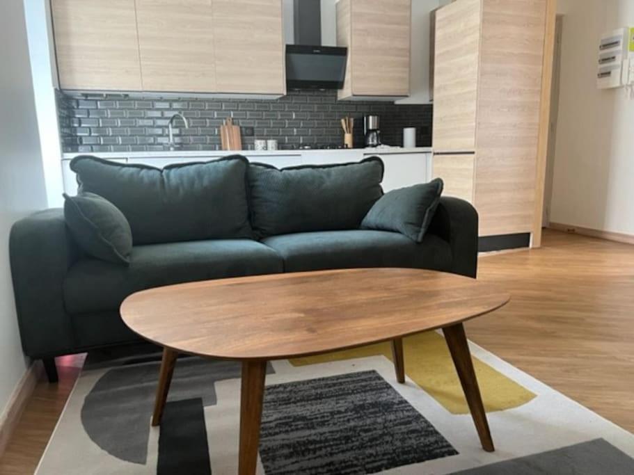 uma sala de estar com um sofá e uma mesa de madeira em Apt Moderne 2 chambres 5 voyageurs Paris em Paris
