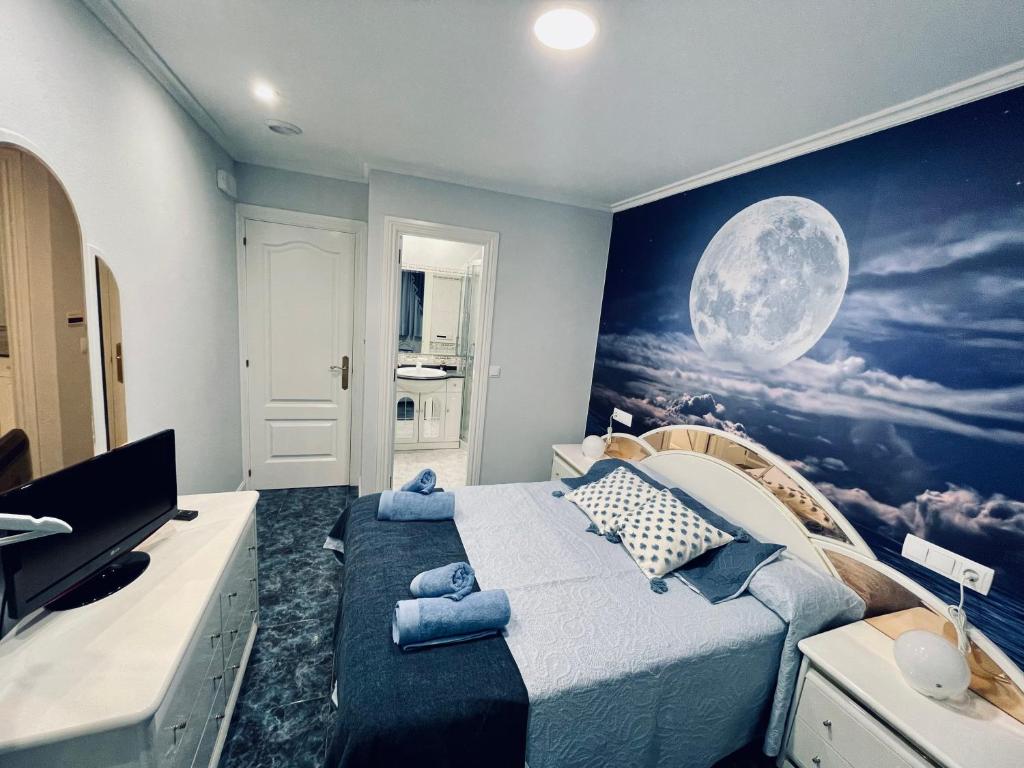 a bedroom with a bed with a mural of the moon at Luna Llena (Soria) in Soria