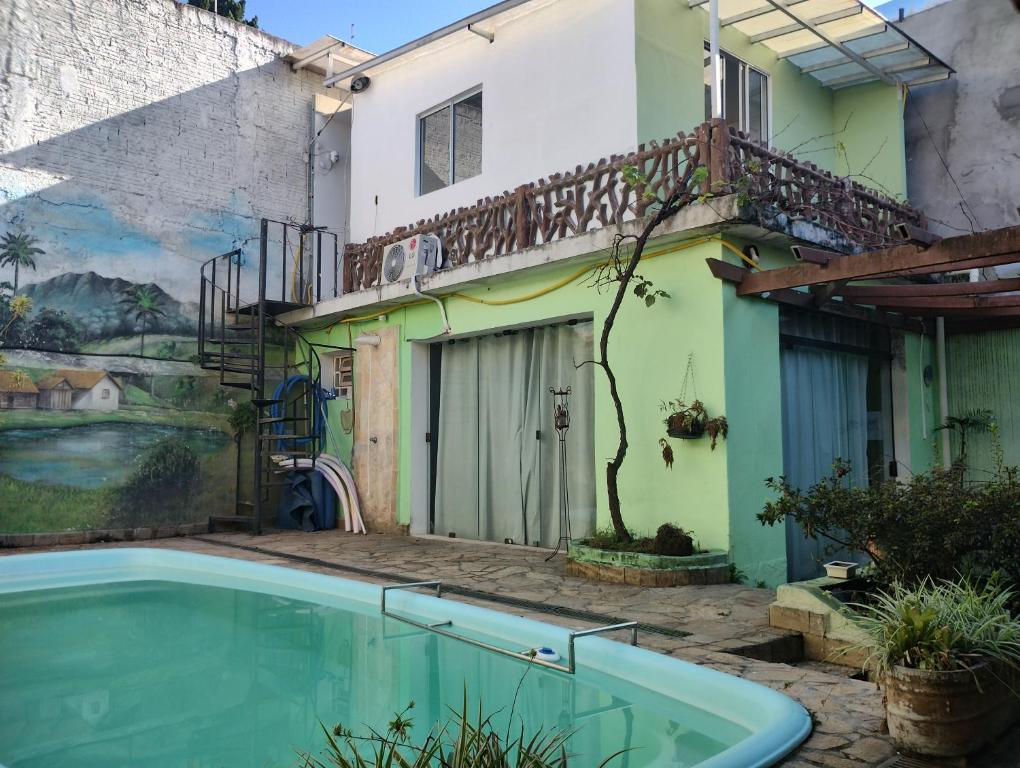 a swimming pool in front of a building with a mural at Hostel Jardim da Saúde in Sao Paulo