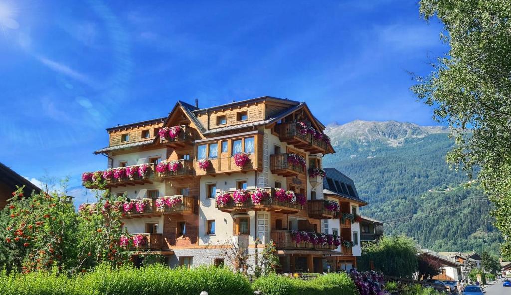 a building with flower boxes on the side of it at Sottovento Luxury Hospitality in Bormio
