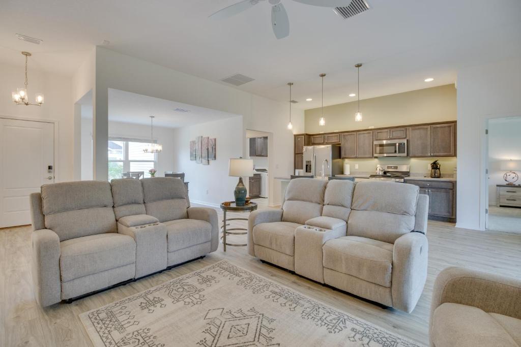 a living room with two chairs and a kitchen at Pool Access Sleek Home in The Villages with Lanai in The Villages