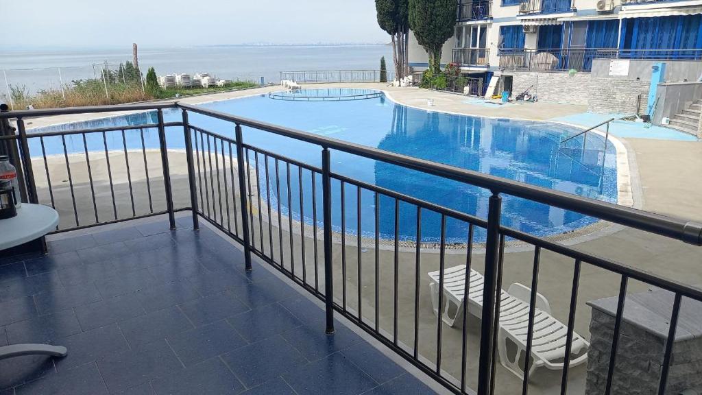 a balcony with a view of a swimming pool at Pomorie Direkt am Pool in Pomorie