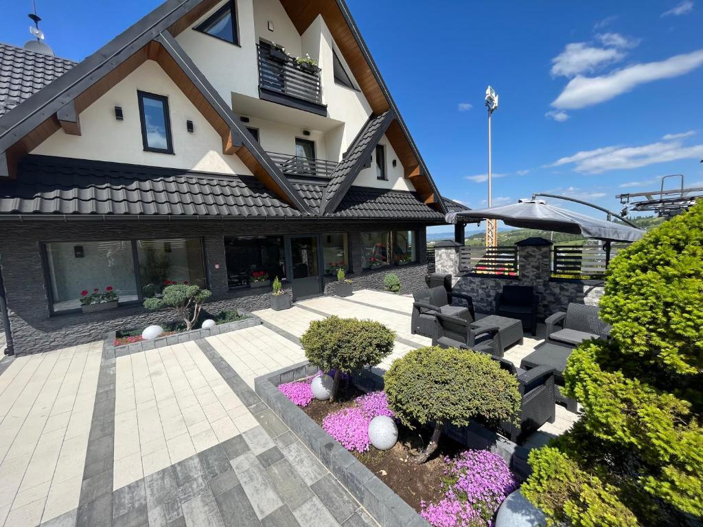 une maison avec une terrasse ornée de fleurs violettes dans l'établissement Baranek, à Czerwienne