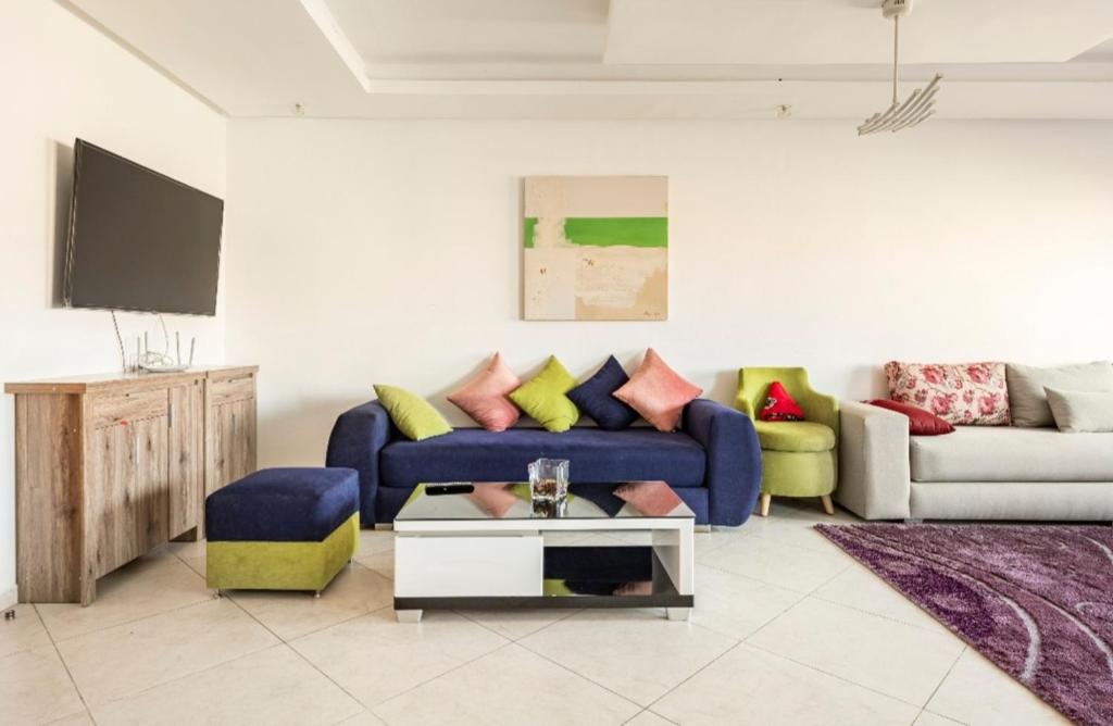 a living room with a blue couch and a tv at Appartement 26 ensoleillé à 5 min de la plage El Jadida in El Jadida