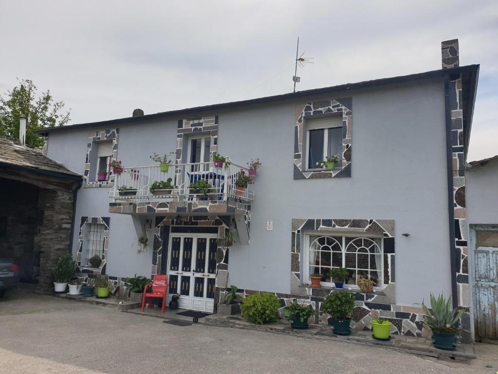 a white house with potted plants on the windows at ANAMAR in Lugo