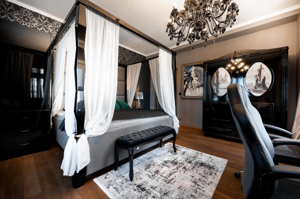 Premium Apt Kosice Center 3 room with PARKING في كوشيتسه: غرفة نوم بسرير مظلة مع كرسي وثريا