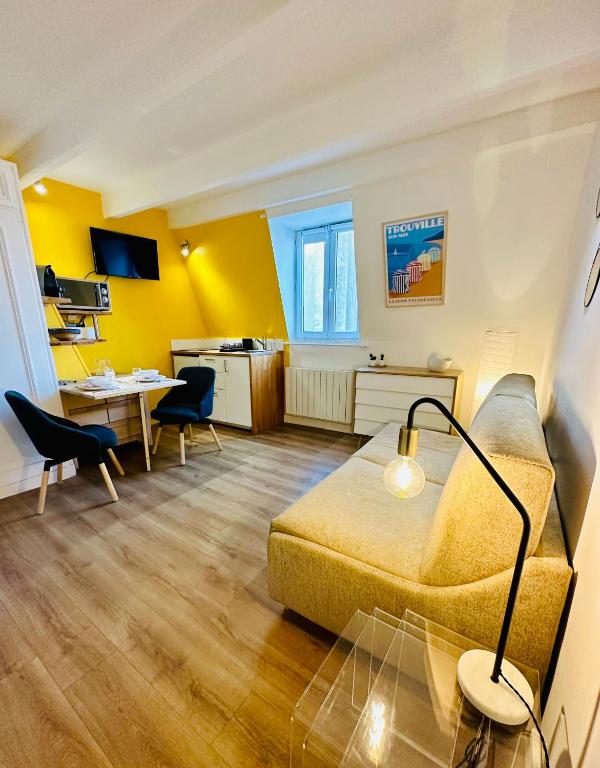 un salon avec un canapé et une table dans l'établissement Studio Hissez Haut - idéalement placé, plage, restaurants, commerces, à Trouville-sur-Mer
