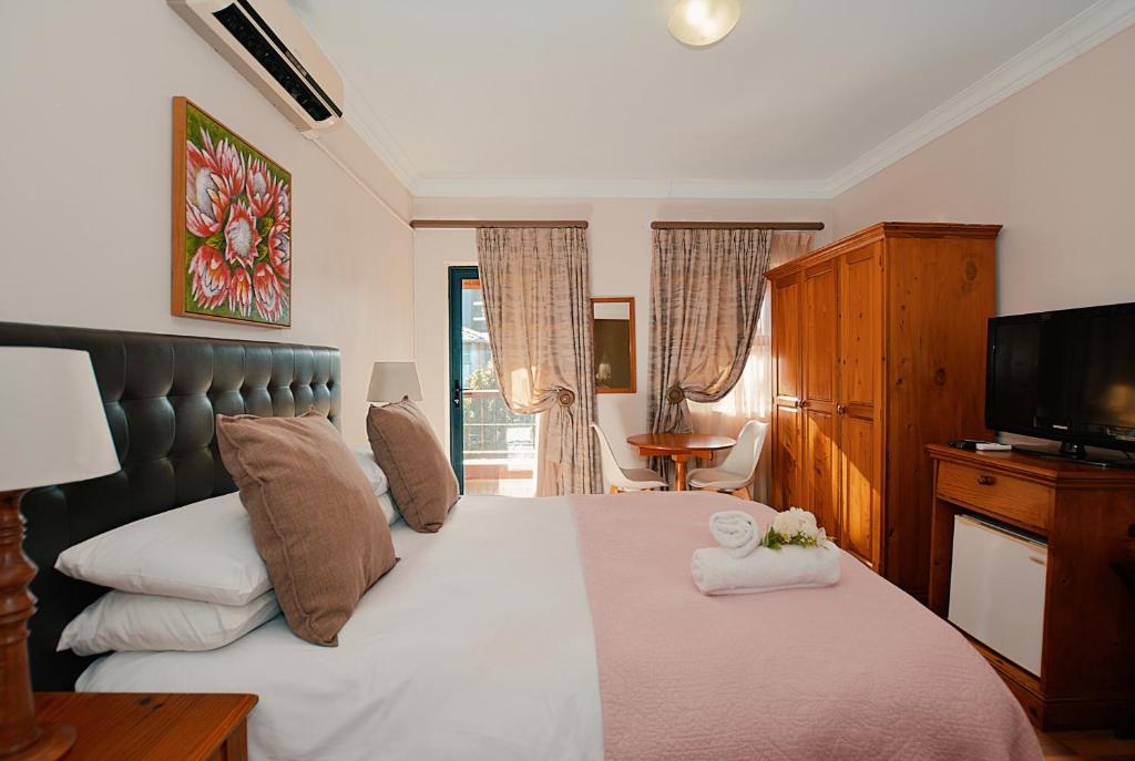 a bedroom with a large bed with a tv on it at ALBATROSS SUITE in Cape Town