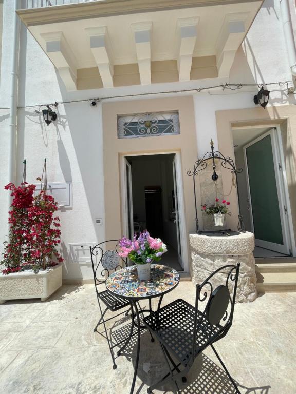 a patio with a table and chairs and flowers at L'Antico Pozzo in Pozzallo