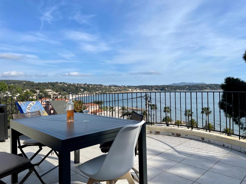 une table et des chaises sur un balcon avec vue sur l'océan dans l'établissement Bandol : Très bel Appartement Avec Grande Terrasse et vue Exceptionnelle sur mer, à Bandol