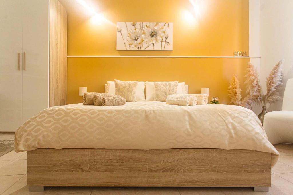 sypialnia z dużym łóżkiem i żółtą ścianą w obiekcie Montellino's Suite Oro w mieście SantʼAntìoco