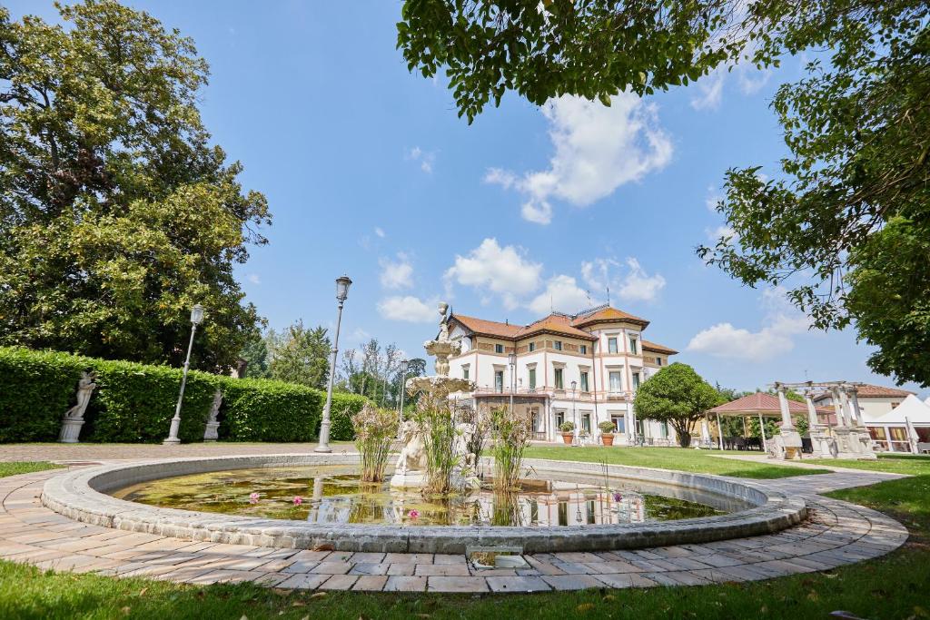 una fuente frente a una casa grande en Hotel Villa Stucky, en Mogliano Veneto