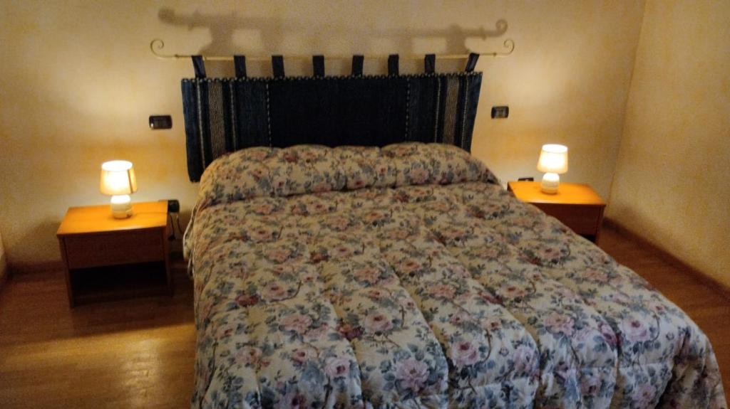 um quarto com uma cama com duas luzes em duas mesas em B&B DA SILVESTRO em Tempio Pausania