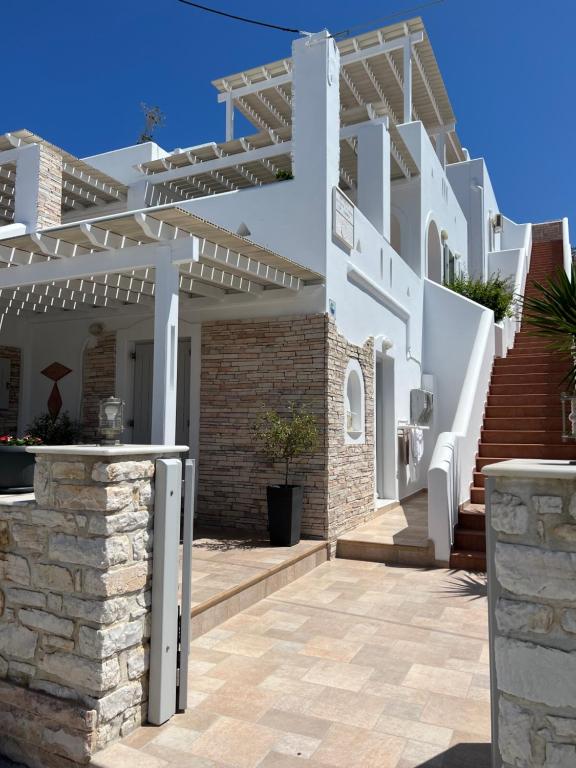 a white house with a white pergola at Katerina Apartments & Studios in Naousa