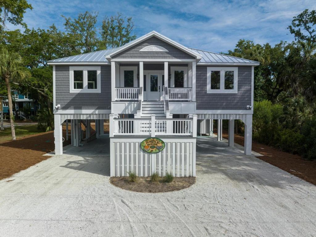 a house on a beach with a white fence at The Jungle House in Edisto Island