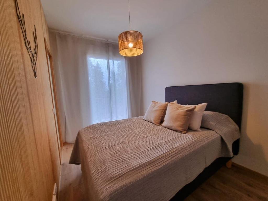 a bedroom with a bed with two pillows and a window at Kivikatu Apartment in Rovaniemi