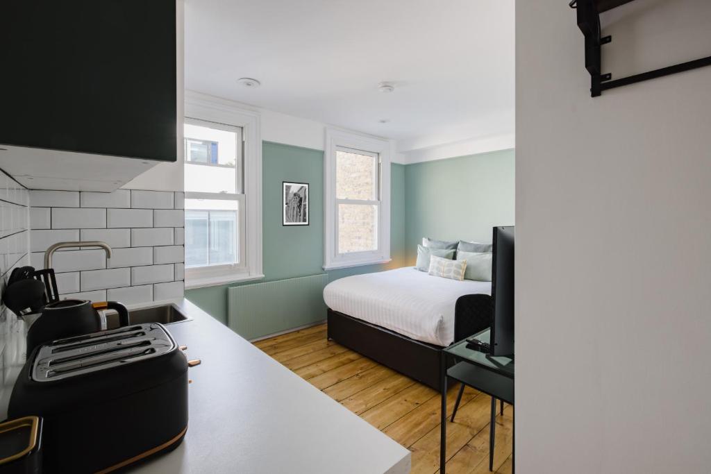 a small bedroom with a bed and a kitchen at CitySpace Kings Cross in London