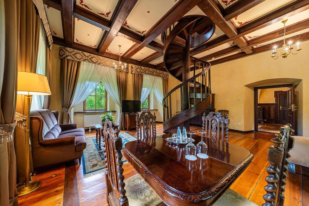 Elegant living room with wooden spiral staircase, plush seating, and large windows with curtains.