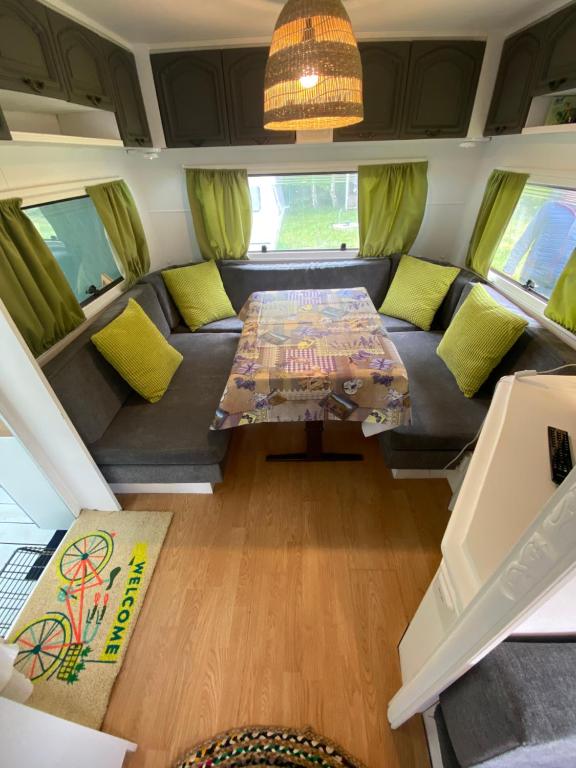 a living room in a rv with a couch and a table at Przyczepa Abordaż Wolin in Kołczewo