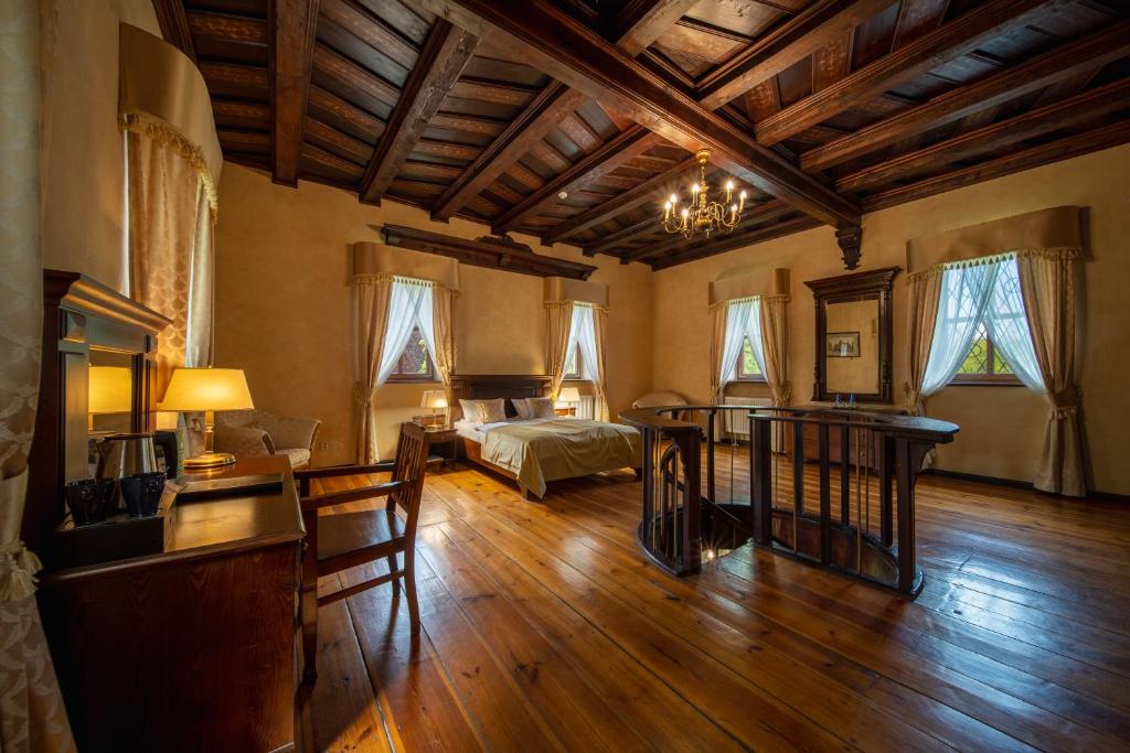 Spacious rustic bedroom with wooden ceiling, elegant furnishings, and warm lighting.
